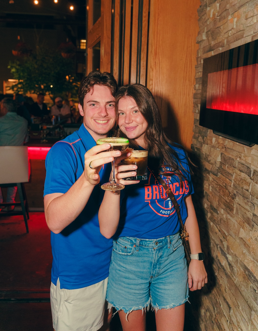 Picture of people, wearing Boise State gear, at Amsterdam Lounge in Boise Idaho